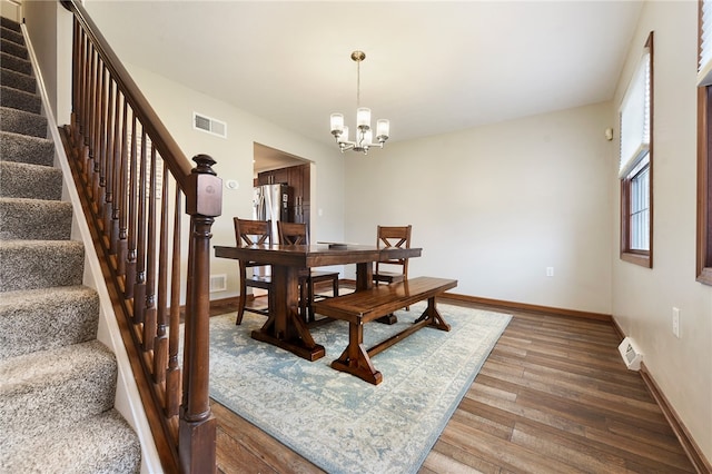 dining room with hardwood / wood-style flooring and a chandelier