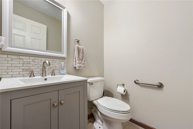 bathroom featuring vanity, toilet, and backsplash