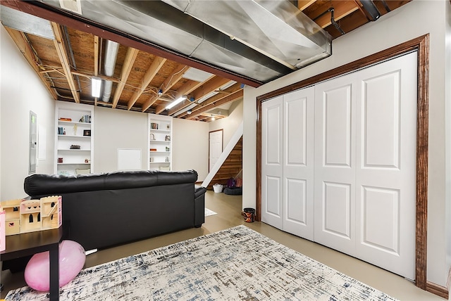 living room with built in shelves and electric panel