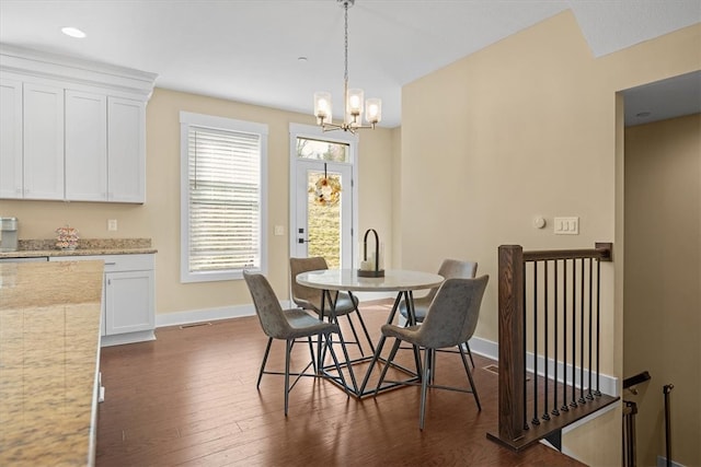 dining space featuring dark hardwood / wood-style flooring and an inviting chandelier