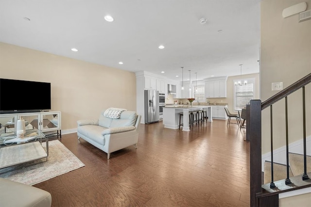 living room with a chandelier and dark hardwood / wood-style floors