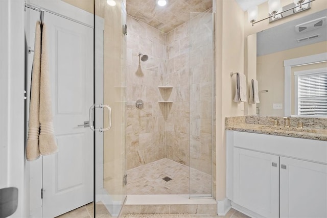 bathroom featuring tile patterned flooring, vanity, and a shower with door