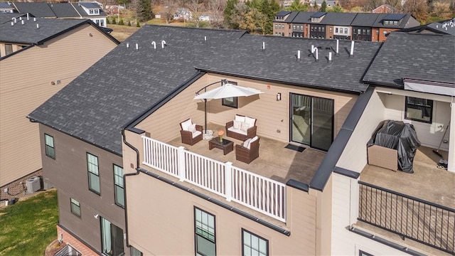 rear view of house with an outdoor living space, a balcony, and central AC unit