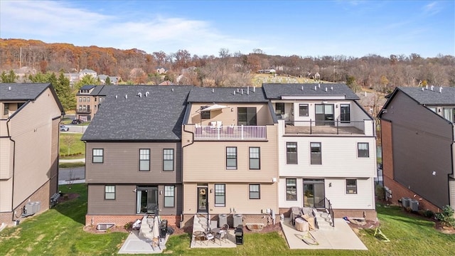 back of property featuring a patio area, a balcony, central air condition unit, and a yard