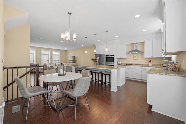 dining space featuring sink, dark wood-type flooring, and a chandelier