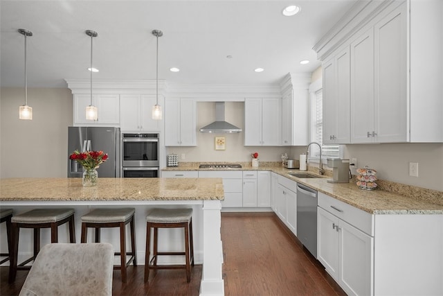 kitchen featuring a center island, sink, wall chimney exhaust hood, stainless steel appliances, and white cabinets