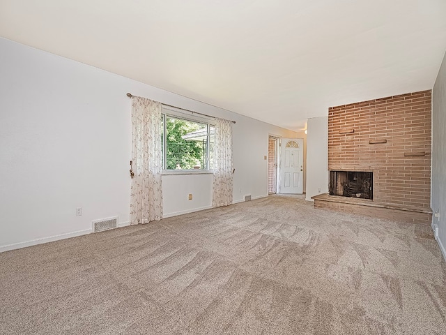 unfurnished living room with carpet flooring and a fireplace