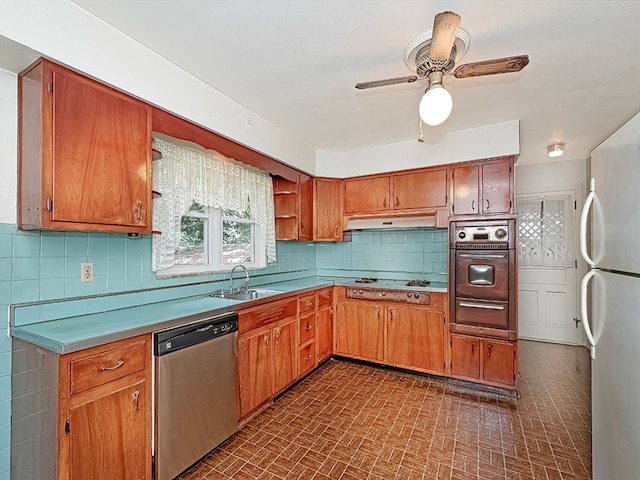 kitchen with backsplash, ceiling fan, sink, and stainless steel appliances