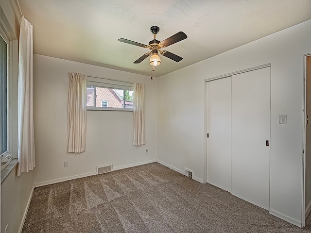 unfurnished bedroom featuring ceiling fan, a closet, and carpet floors