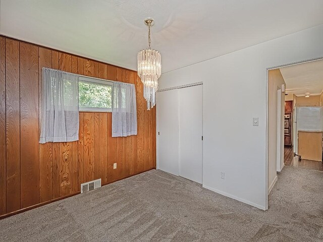 316 Jefferson, Verona, PA 15147 - carpeted empty room with a chandelier, wood walls, and baseboards