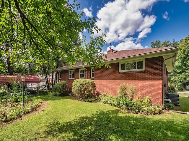 exterior space featuring a lawn and central AC unit