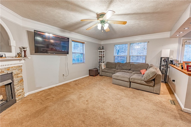 carpeted living room featuring a fireplace, ceiling fan, plenty of natural light, and a textured ceiling