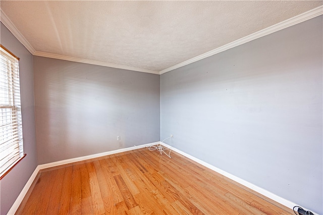 empty room featuring crown molding, hardwood / wood-style floors, and a textured ceiling