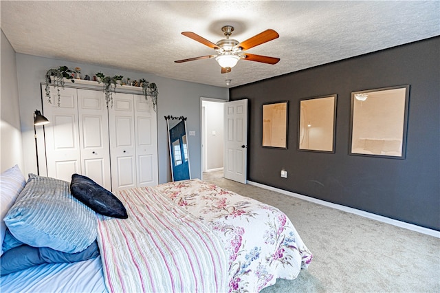 bedroom featuring carpet flooring, ceiling fan, a closet, and a textured ceiling