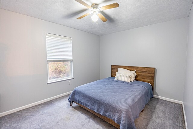 carpeted bedroom with ceiling fan and a textured ceiling