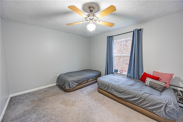 carpeted bedroom featuring a textured ceiling and ceiling fan