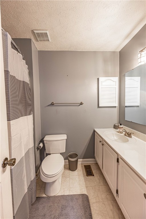 bathroom with vanity, toilet, and a textured ceiling