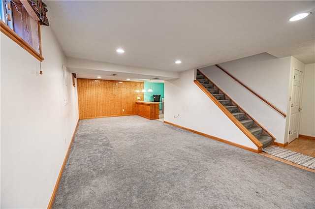 basement with wood walls and carpet floors