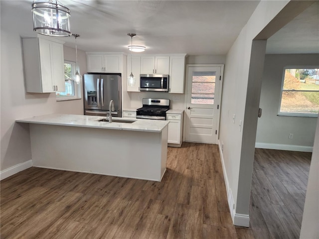 kitchen with dark hardwood / wood-style floors, white cabinetry, hanging light fixtures, and appliances with stainless steel finishes