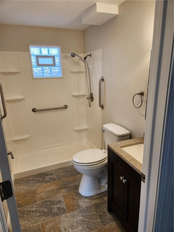 bathroom featuring vanity, toilet, and walk in shower