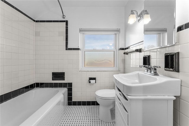 bathroom with a bathing tub, vanity, tile walls, and toilet