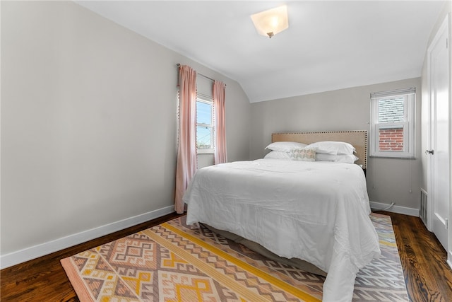 bedroom featuring dark hardwood / wood-style floors, vaulted ceiling, and multiple windows