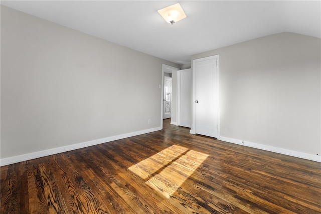 spare room with lofted ceiling and dark hardwood / wood-style floors