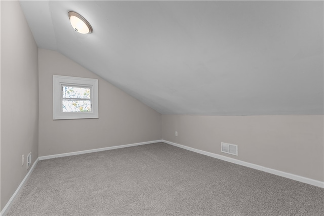 additional living space featuring carpet flooring and lofted ceiling