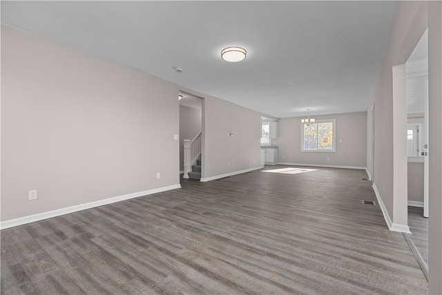 unfurnished living room featuring hardwood / wood-style flooring and an inviting chandelier