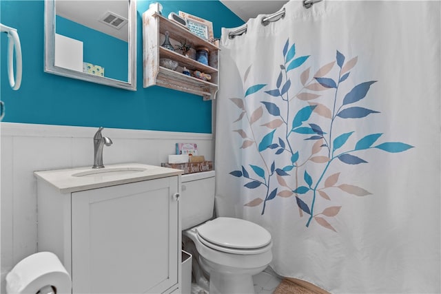 bathroom featuring vanity, toilet, and curtained shower