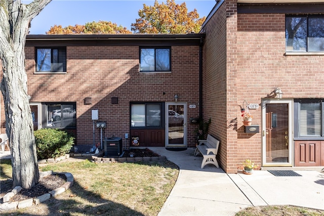 view of front facade with cooling unit, a patio, and a front yard