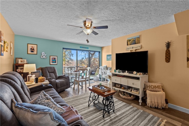 living room featuring ceiling fan, wood-type flooring, and a textured ceiling