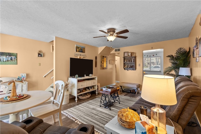 living room featuring hardwood / wood-style floors, a textured ceiling, and ceiling fan