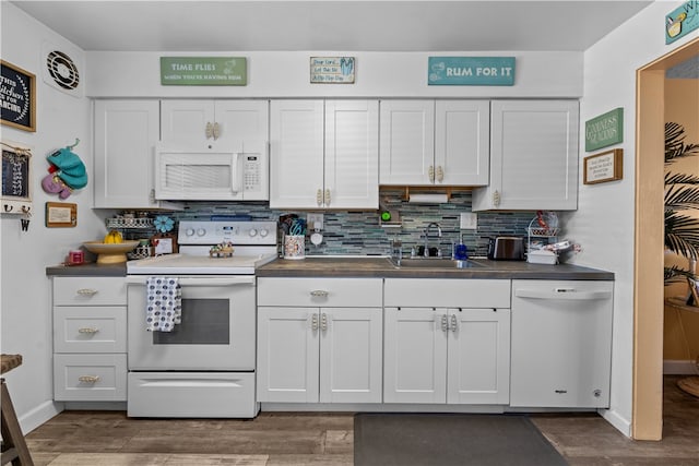 kitchen featuring sink, dark hardwood / wood-style flooring, white appliances, decorative backsplash, and white cabinets