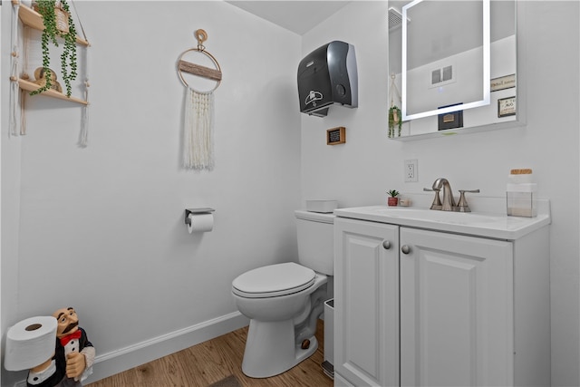 bathroom featuring wood-type flooring, vanity, and toilet