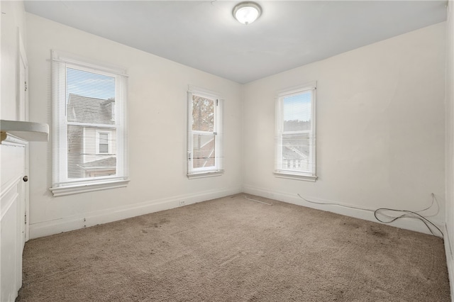 carpeted empty room featuring a wealth of natural light