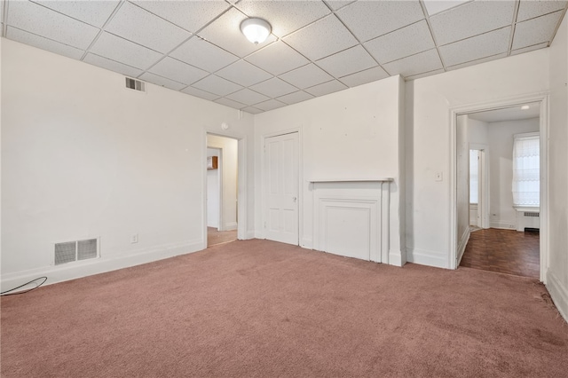 unfurnished room featuring radiator, a paneled ceiling, and carpet