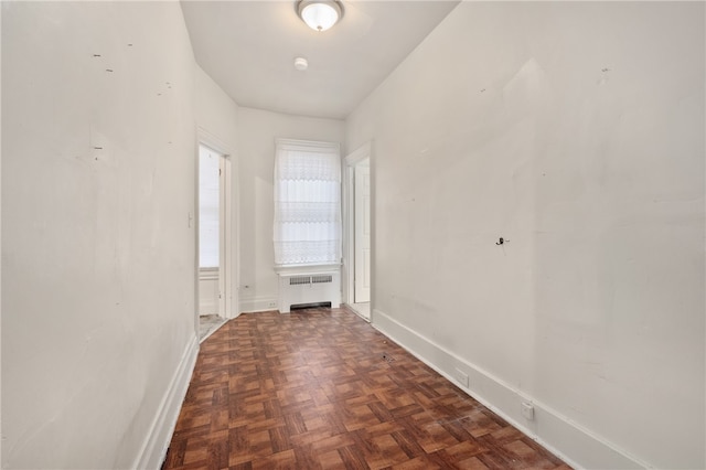 corridor with radiator and dark parquet flooring