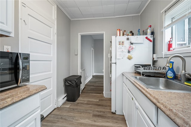 kitchen with white cabinetry, sink, white refrigerator, crown molding, and hardwood / wood-style flooring