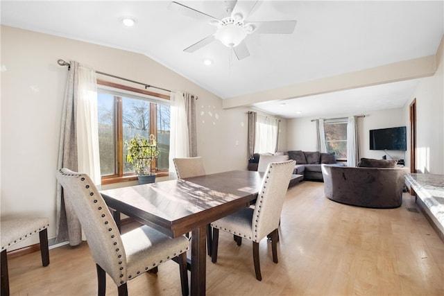 dining area with ceiling fan, light hardwood / wood-style floors, and vaulted ceiling