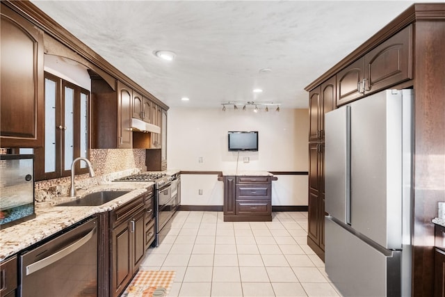 kitchen featuring light stone countertops, appliances with stainless steel finishes, dark brown cabinets, and sink