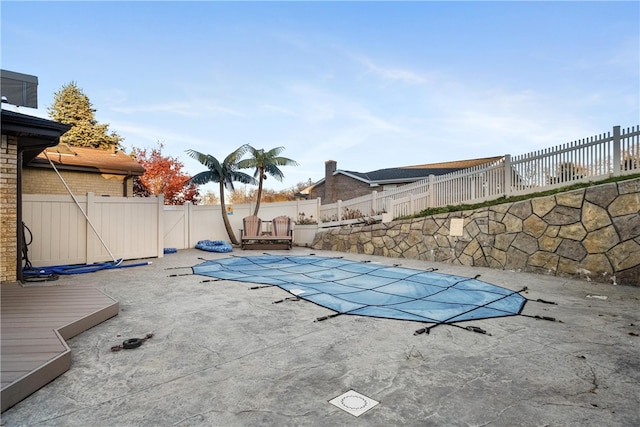 view of pool featuring a patio area and a wooden deck