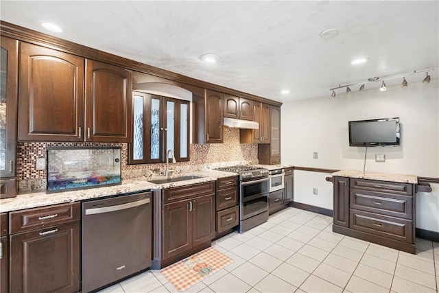 kitchen with dark brown cabinets, sink, light stone counters, and stainless steel appliances