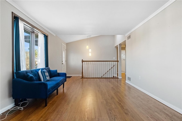 living area with hardwood / wood-style floors, lofted ceiling, and ornamental molding