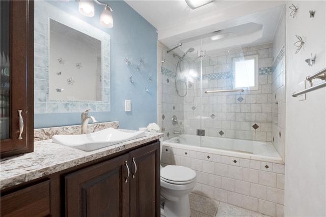 full bathroom with tile patterned floors, vanity, tiled shower / bath combo, and toilet