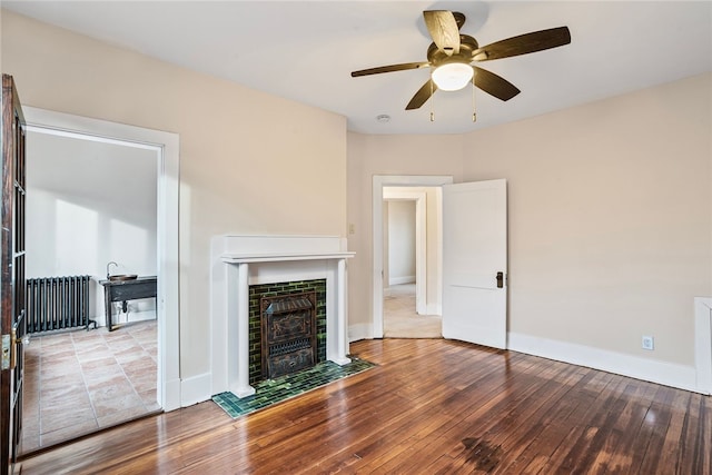 unfurnished living room featuring radiator, ceiling fan, and light hardwood / wood-style flooring