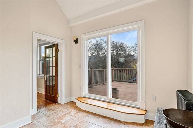 doorway to outside featuring vaulted ceiling