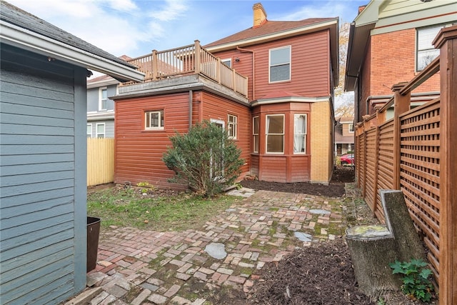 rear view of property featuring a balcony and a patio