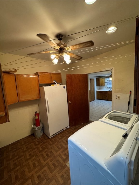 laundry room featuring washing machine and clothes dryer, dark parquet flooring, ceiling fan, and cabinets