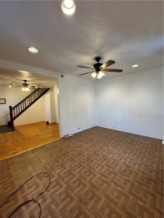 unfurnished room featuring dark parquet flooring and a textured ceiling